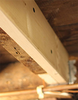 new wooden beam in a crawl space repair